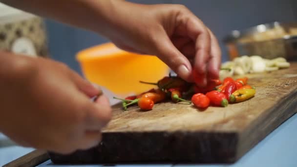 一个女人的手在厨房里擦红辣椒做饭 — 图库视频影像