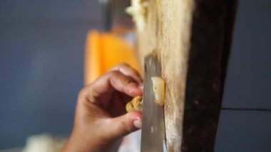 Mutfak bıçağıyla sığır derisini kesen bir kadının dikey videosu.