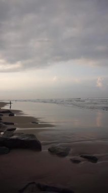 Dikey güzel plaj portresi görüntüsü öğleden sonra, küçük dalgaları ve kumsalı görebilirsiniz.