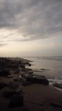 Dikey güzel plaj portresi görüntüsü öğleden sonra, küçük dalgaları ve kumsalı görebilirsiniz.