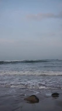 Dikey güzel plaj portresi görüntüsü öğleden sonra, küçük dalgaları ve kumsalı görebilirsiniz.