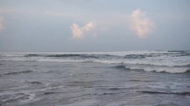 Öğleden sonra güzel bir sahil manzarası görünür küçük dalgalar ve kumsal.