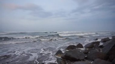 Öğleden sonra güzel bir sahil manzarası görünür küçük dalgalar ve kumsal.