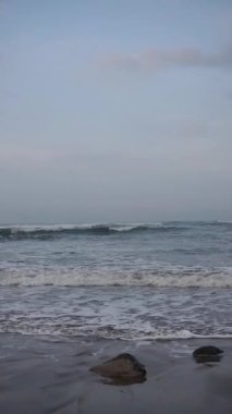 Güzel dikey plaj portresi videoları, sabahları manzara, Cipatujah sahilindeki küçük dalgaların görüntüsü.