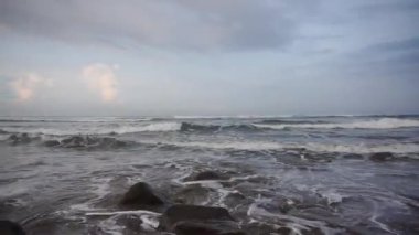 Öğleden sonra güzel bir sahil manzarası görünür küçük dalgalar ve kumsal.