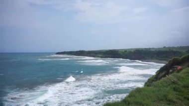 Mağaranın tepesinden, Garut, Batı Cava, Endonezya 'nın güney sahilinden güzel bir manzara. Gün boyunca mavi deniz suyuyla birlikte büyük dalgaların olduğu bir kumsal görebilirsiniz.