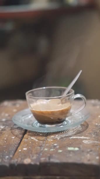屋内の白いガラスでかき混ぜられたミルクコーヒーのビデオ映像 — ストック動画