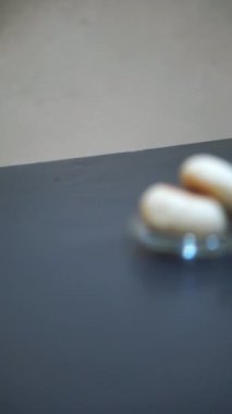 Bir fincan çay ve yeşil fasulye ekmeği, siyah masada yemeye hazır.