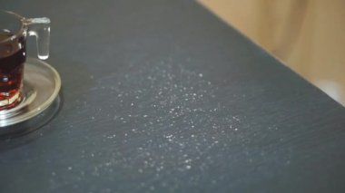 Bir fincan çay ve yeşil fasulye ekmeği, siyah masada yemeye hazır.