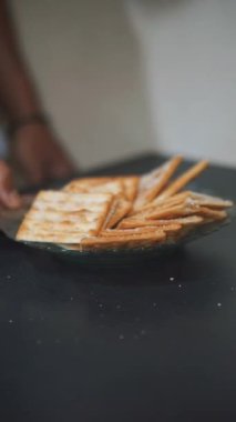 Bir adamın elleri bir tabakta bisküvi düzenliyor.