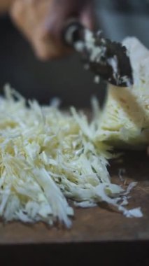 Adamın biri mutfak bıçağıyla lahana dilimliyordu.