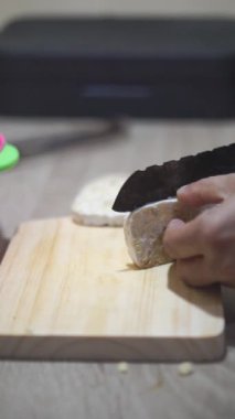 Güzel dikey video portresi, Tempeh 'i mutfak bıçağıyla dilimlemek.