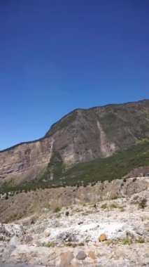 Garut, Batı Java, Endonezya 'da ölü bir orman olan Papandayan Dağı' nın yüksek uçurumlarıyla parlak manzaralı güzel bir dikey video.