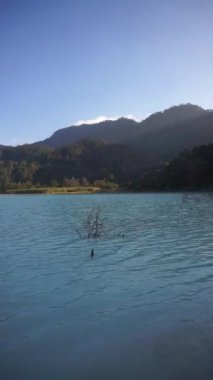 Talaga bodas krateri, Garut Endonezya 'da turistik bir yer, öğleden sonra açık mavi gökyüzünün altında yeşil ağaçlar.