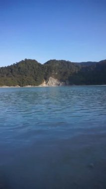 Talaga Bodas krater gölü, Garut 'ta turistik bir yer. Akşamüstü mavi gökyüzünün altında yeşil ağaçlar var.