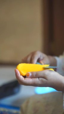 Bir kadının eli, özel olgun bir meyveyi mutfak bıçağıyla dilimliyor.