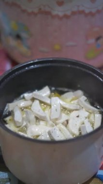 İnce dilimlenmiş köfteler pişirip elektrikli fritözde kızartılan güzel dikey video portresinin adı Basreng, tipik bir Endonezya atıştırmalığı..