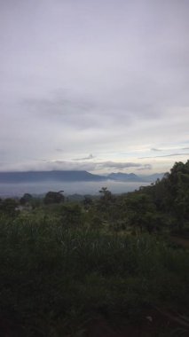 Yeşil dağların doğal manzarası, tepelerin panoramik manzarası, gün boyunca açık gökyüzü.