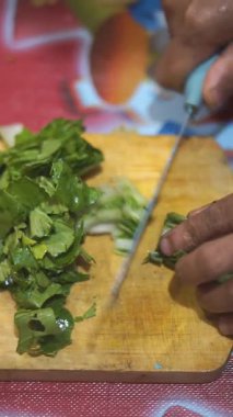 Adamın biri yeşil hardal yeşili kesiyor ya da Latin Brassica rapa 'da, mutfak bıçağıyla..