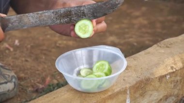 Bir adam bir salatalık kesiyor ya da Latin salatalık desenli, mutfak bıçağıyla..