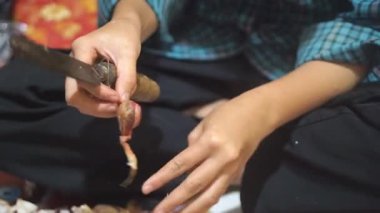 Genç bir kız kırmızı soğan soyuyor.