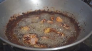 Kızartma tavasında tavuğu gaz sobasıyla kızartmak.