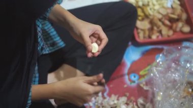 Genç bir kız baharat pişirmek için sarımsak soyuyor.