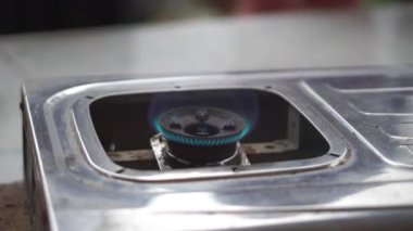 Birisi yeni tamir edilmiş bir gaz sobasını yakmaya çalışıyor ve ocak tutuşuyor..