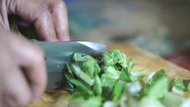 Adamın biri yeşil hardal yeşili kesiyor ya da Latin Brassica rapa 'da, mutfak bıçağıyla..