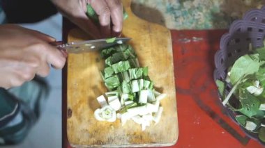 Adamın biri yeşil hardal yeşili kesiyor ya da Latin Brassica rapa 'da, mutfak bıçağıyla..