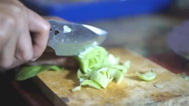 Adamın biri yeşil hardal yeşili kesiyor ya da Latin Brassica rapa 'da, mutfak bıçağıyla..