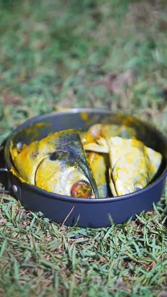 Latin Sphyraena putnamae 'deki barakuda balığı kızartma tavasında baharat ve zerdeçal ile tatlandırılmıştır.