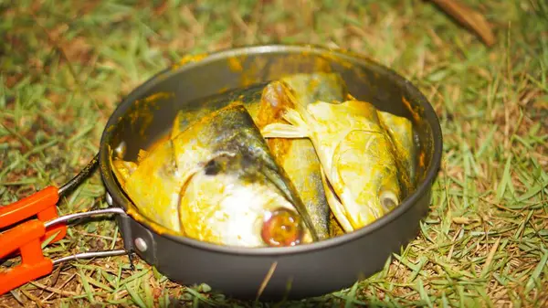 Latin Sphyraena putnamae 'deki barakuda balığı kızartma tavasında baharat ve zerdeçal ile tatlandırılmıştır.