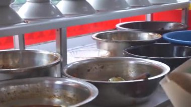 Bir kadın hizmetçi Padang restoranında yemek paketliyor..