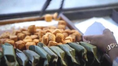 Bir Sumedang tofu tüccarının elleri müşterisinin sipariş ettiği tofuyu sayıyor.