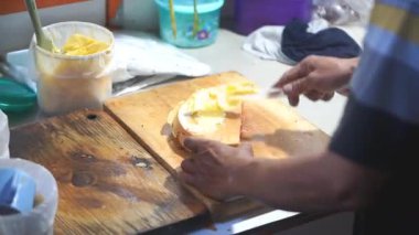 Bir sokak satıcısı sattığı martabak 'a tereyağı sürüyor..