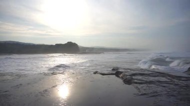 Büyük deniz suyu dalgaları sabah alçak gelgit sırasında gün doğumunda
