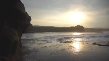 Büyük deniz suyu dalgaları sabah alçak gelgit sırasında gün doğumunda