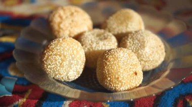 Onde-onde veya geleneksel susam topları tatlı mung fasulye ezmesi ile doldurulmuş, dekoratif bir tabakta servis edilen popüler bir Asya atıştırmalığı