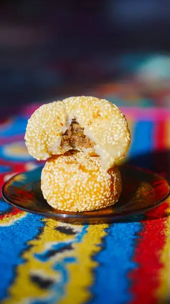 Onde-onde veya geleneksel susam topları tatlı mung fasulye ezmesi ile doldurulmuş, dekoratif bir tabakta servis edilen popüler bir Asya atıştırmalığı