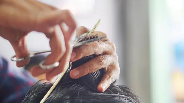 Geleneksel saç kesim tekniği. Deneyimli bir kuaförün makas ve tarak kullanması.