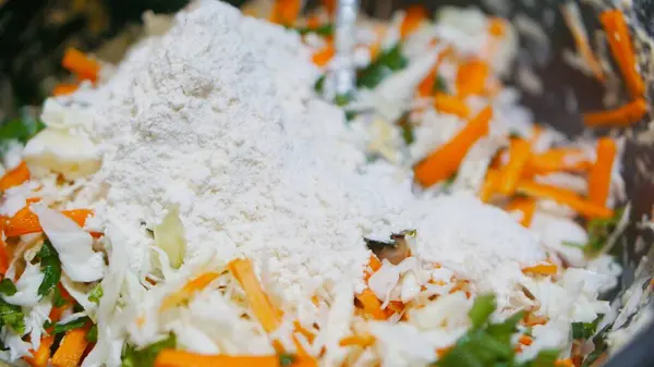 Kızartmaya hazır havuç, lahana ve otlarla karışık sebze hamuru yakın plan.