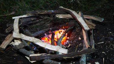 Ormanda geleneksel kamp ateşi, kendine güvenmeyi, macerayı ve ilkel açık havada yaşamayı simgeliyor.