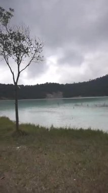 Sisli volkanik göl Talaga Bodas Garut Endonezya 'da bulutlu gökyüzünün altında, ormanlar ve sakin sularla çevrili, bir yalnızlık ve huzur hissi uyandırıyor..