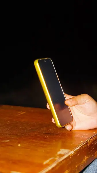 Geceleri sarılı, modern bir akıllı telefon tutan adam..