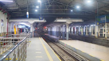 Bandung, Endonezya - 13 Ağustos 2025 Yolcular bir Endonezya tren istasyonunun platformunda bekliyorlar, günlük toplu taşımacılık rutinini resmediyorlar..