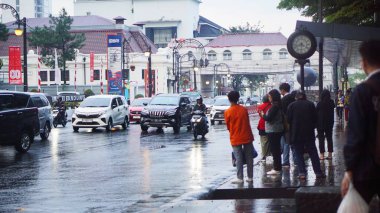 Bandung, Endonezya - 13 Ağustos 2025 Trafiği ve insanlar Endonezya 'da yağmur sırasında ıslak yollarda hareket ederek şehir ulaşımının dinamiklerini resmediyorlar..
