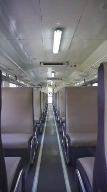 Bandung Endonezya - 25 Eylül 2025 Simetrik sıra koltuk ve metal tırabzan ile içi boş tren iç mekanı, minimalist bir bakış açısı yaratıyor