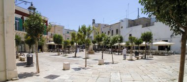 Monopoli, İtalya. 06 29 2019. Monopoli şehrinin tarihi eski kasabasında evler ve restoranlar. Giuseppe Garibaldi Meydanı güneşli bir yaz gününde.