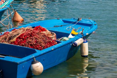Monopoli, Puglia, İtalya 'da balık ağı ve teçhizat. Mavi tekne Monopoli rıhtımında geleneksel balıkçılık malzemeleriyle demirlemiş..